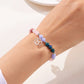 Armband med 12 stjärntecken och pärlor och berlock med astrologiska tecken